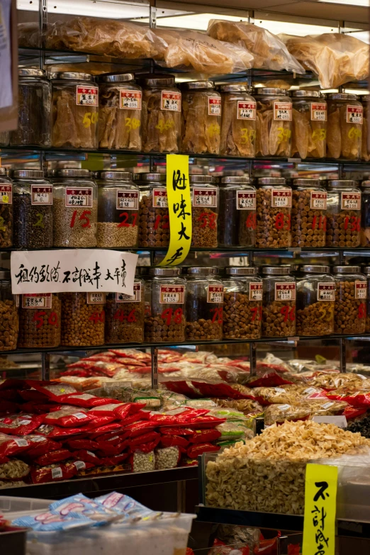 a store filled with lots of different types of food, a picture, chinatown, dried petals, jar on a shelf, square