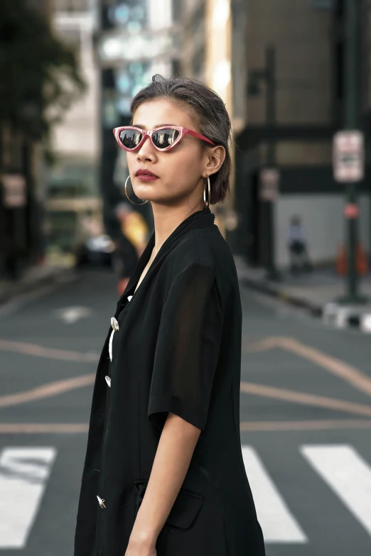 a woman standing in the middle of a street, inspired by Ina Wong, featured on instagram, pop art, wear ray - ban glass, black and red colour palette, close up half body shot, styling