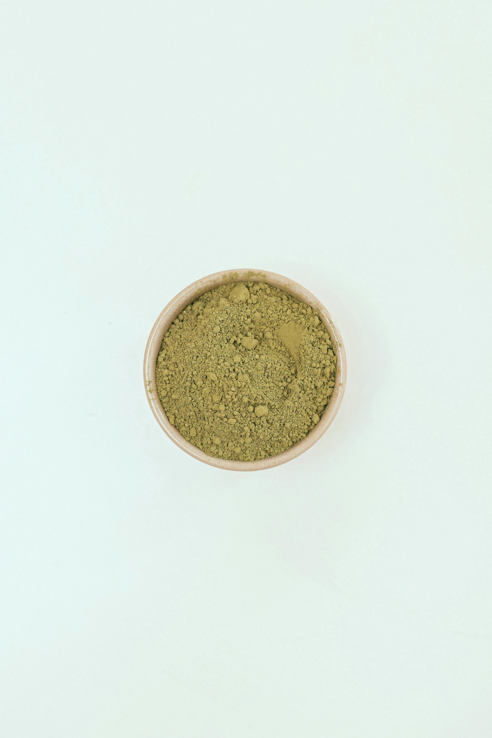 a bowl filled with green powder on top of a white table, golden ration, detailed product image, mild, frontal shot