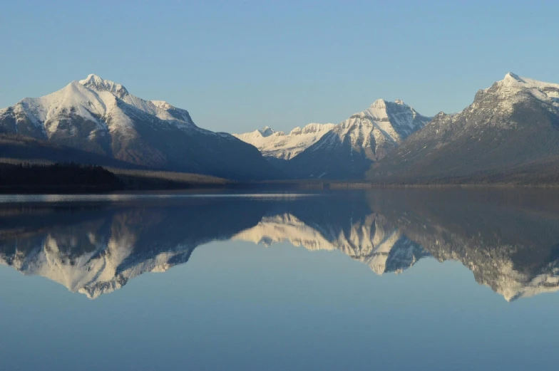 a large body of water with mountains in the background, a picture, mirroring, montana, body of water