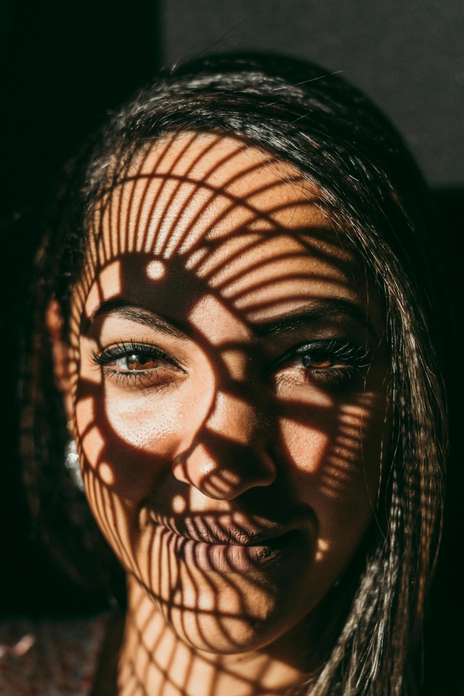 a close up of a person with long hair, pexels contest winner, optical illusion, faces covered in shadows, smiling woman, tan skin, backlight