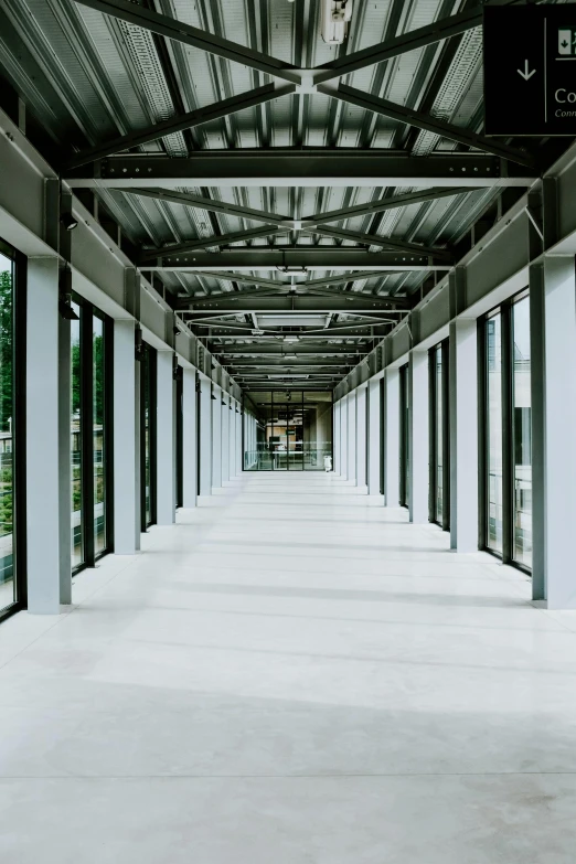 a long hallway in a building with lots of windows, inspired by David Chipperfield, industrial environment, no - text no - logo, shops, seasonal