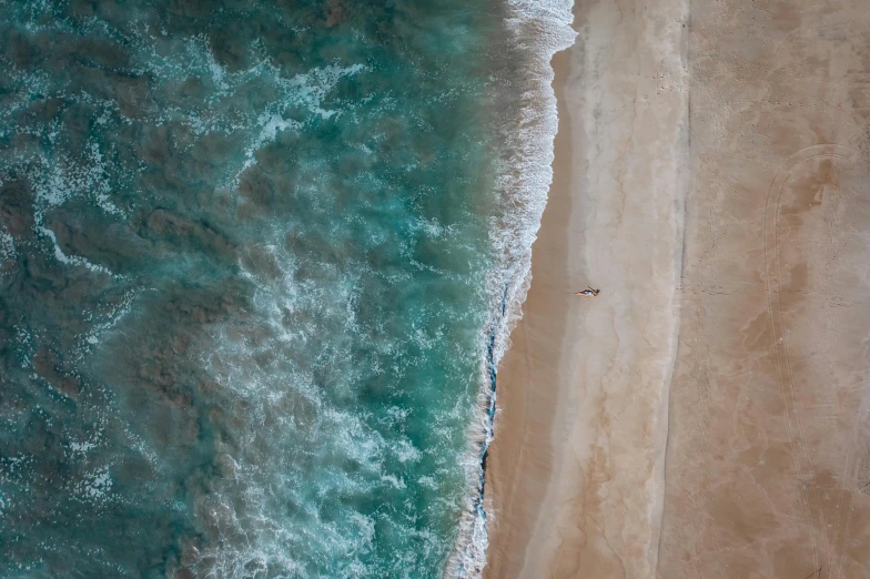 a couple of people standing on top of a sandy beach, pexels contest winner, minimalism, bird\'s eye view, cresting waves and seafoam, is relaxing on a beach, wall of water either side