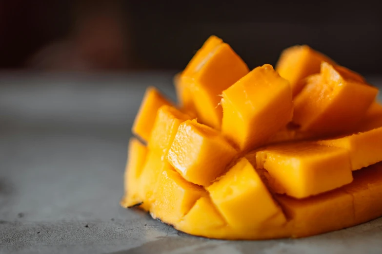 a pile of cubes of mango sitting on top of a counter, a portrait, pexels, round corners, caramel, closeup at the food, tummy