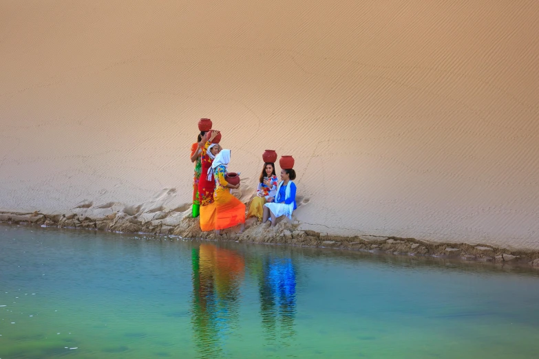 a group of people standing next to a body of water, inspired by Steve McCurry, pexels contest winner, festive colors, tuareg, sand banks, peacefully drinking river water