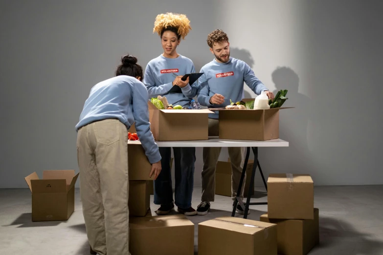 a group of people standing around a table with boxes on it, by Julia Pishtar, shutterstock contest winner, work clothes, epicurious, avatar image, 2 people