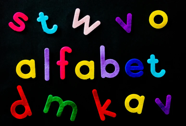 a close up of colorful letters on a black surface, by Claire Falkenstein, pixabay, letterism, jellycat, arabic pronunciation: [kaʕ.bah]), school class, forward facing