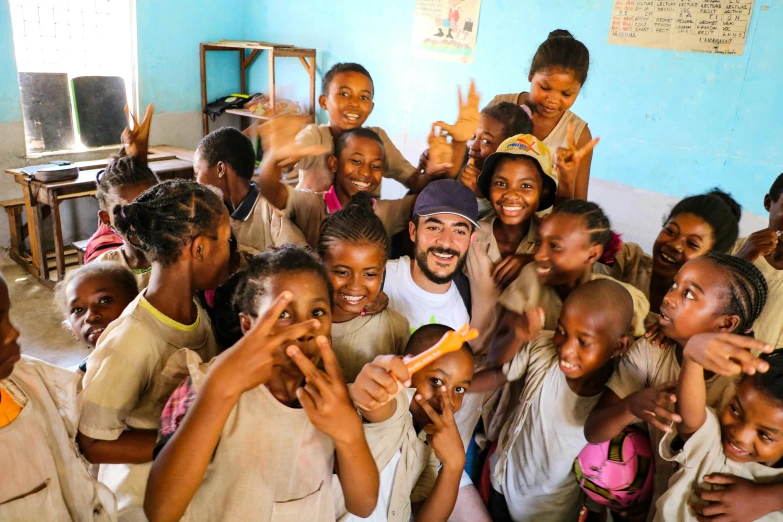 a group of children posing for a picture in a classroom, pexels contest winner, ashcan school, singer maluma, african aaron paul, thumbnail, holding an epée
