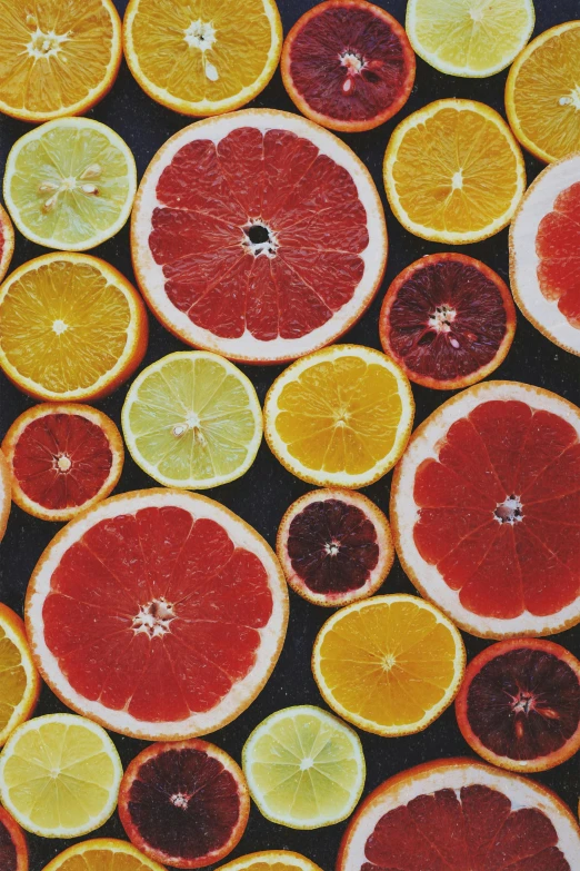 a close up of a bunch of oranges and lemons, an album cover, by Carey Morris, trending on pexels, orange red black white, textile, sliced grapefruit, eyes wide