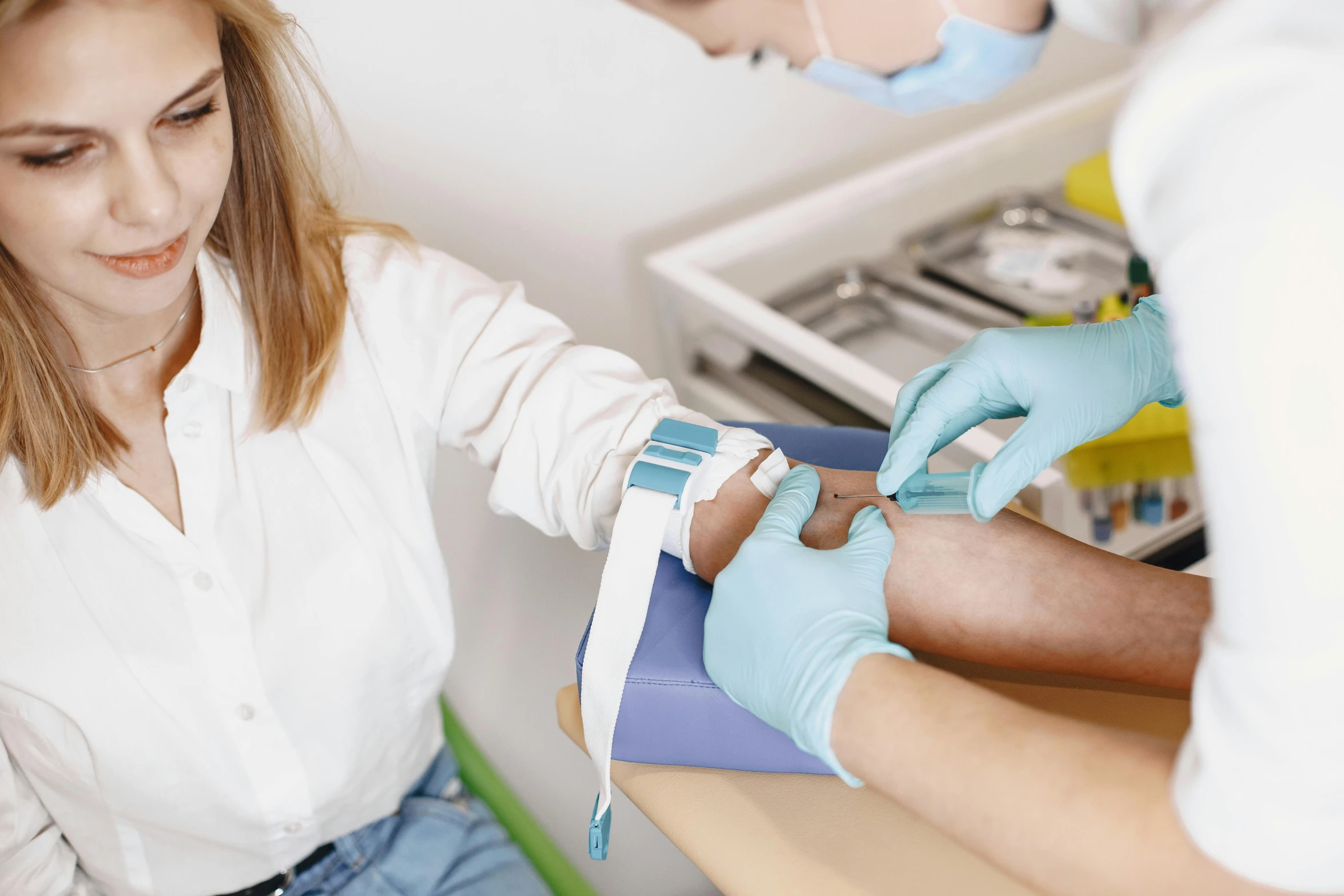 a woman getting an injection from a doctor, a colorized photo, by Adam Marczyński, trending on pexels, hurufiyya, white bandage tape on fists, thumbnail, blood collection vials, blue veins