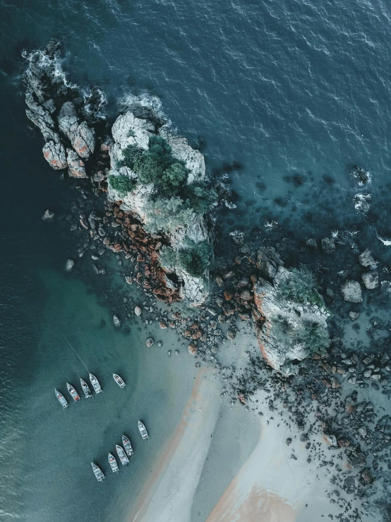 a group of boats floating on top of a body of water, pexels contest winner, south african coast, satelite imagery, rocky shore, close up portrait shot
