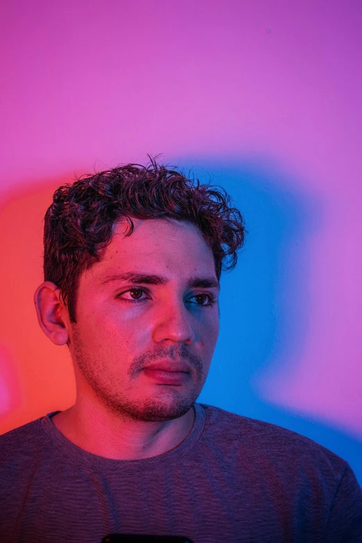 a man is looking at his cell phone, an album cover, inspired by Alexis Grimou, bisexual lighting, headshot profile picture, peruvian looking, multiple colors