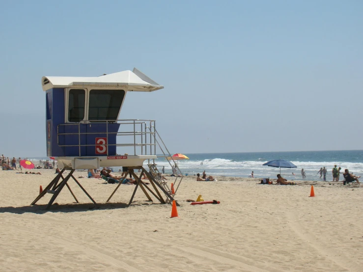 a lifeguard tower sitting on top of a sandy beach, oceanside, square, white beaches, grey