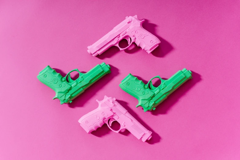 three pink and green toy guns on a pink background, inspired by Gustave Boulanger, trending on pexels, pop art, holster, 3d printed, massacre, paper