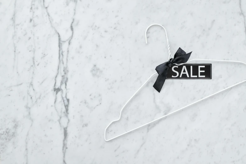 a white hanger with a sale sign on it, unsplash, ornamental bow, all marble, black, made out of shiny white metal