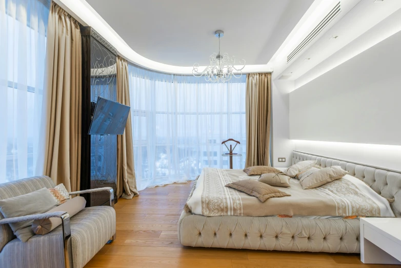 a large bed sitting in a bedroom next to a window, inspired by Illarion Pryanishnikov, unsplash, curved furniture, silver，ivory, city apartment, award-winning cinema