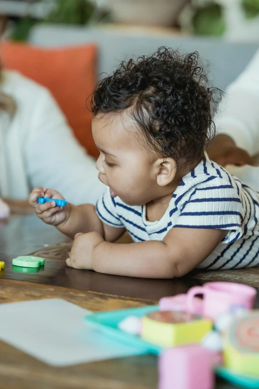 a woman playing with a child at a table, pexels contest winner, fisher price, varying ethnicities, center of picture, plasticine