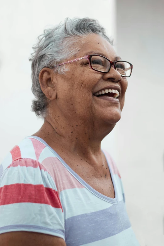 a woman wearing glasses and a striped shirt, pexels contest winner, puerto rico, laughter, an elderly, profile image