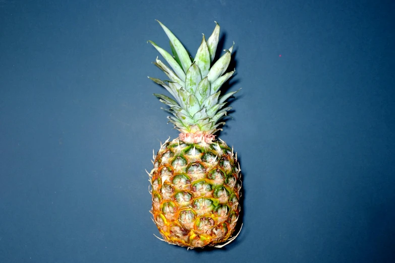 a pineapple sitting on top of a blue surface, with a black background, listing image, a high angle shot, frontal pose