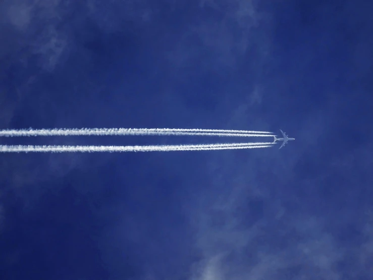 a plane that is flying in the sky, by Paul Bird, pexels contest winner, auto-destructive art, azure blue sky, particulate, very elongated lines, photographed for reuters
