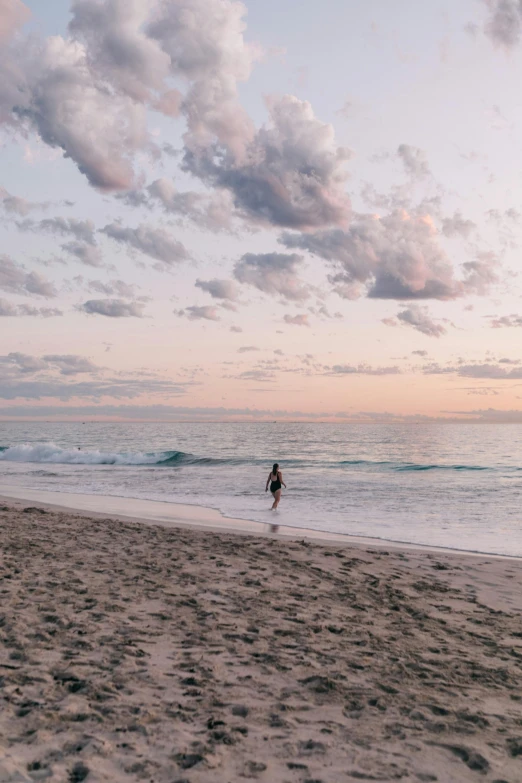 a man standing on top of a sandy beach next to the ocean, during a sunset, caulfield, white beaches, walking down