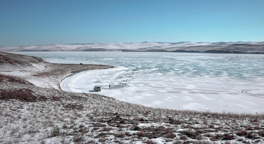 a large body of water sitting on top of a snow covered field, pexels contest winner, land art, mongolia, ai weiwei and gregory crewdson, lake in the distance, vehicle