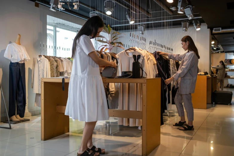 two women are shopping in a clothing store, by Julia Pishtar, pexels contest winner, nico wearing a white dress, taiwan, office clothes, thumbnail