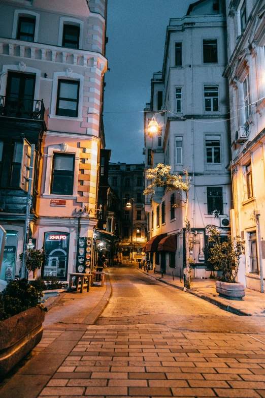 a city street filled with lots of tall buildings, inspired by Elsa Bleda, unsplash contest winner, art nouveau, istanbul, humid evening, square, quaint village
