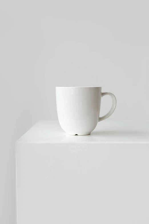 a white cup sitting on top of a white shelf, textured base ; product photos, hero shot, 1 6 x 1 6, round nose