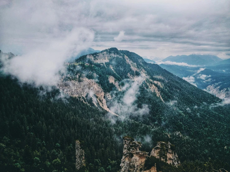 a view of the mountains from the top of a mountain, by Emma Andijewska, pexels contest winner, foggy forrest backdrop, birdseye view, over a cliff, thumbnail