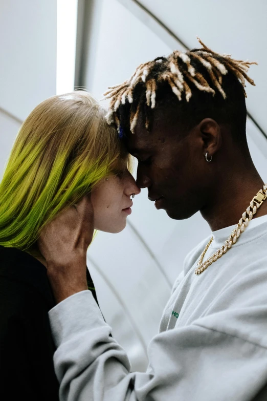 a man and a woman standing next to each other, trending on pexels, visual art, bright green hair, black man, a girl with blonde hair, lily frank