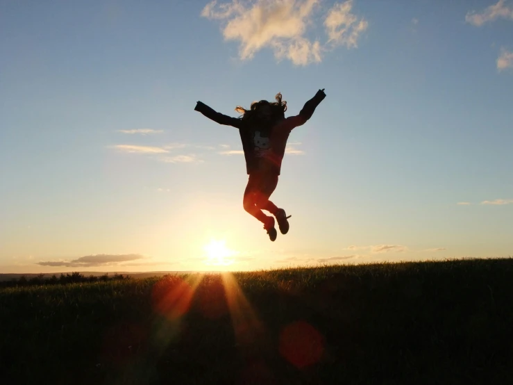 a person jumping in the air at sunset, minna sundberg, smile, basil flying, sun is in the top