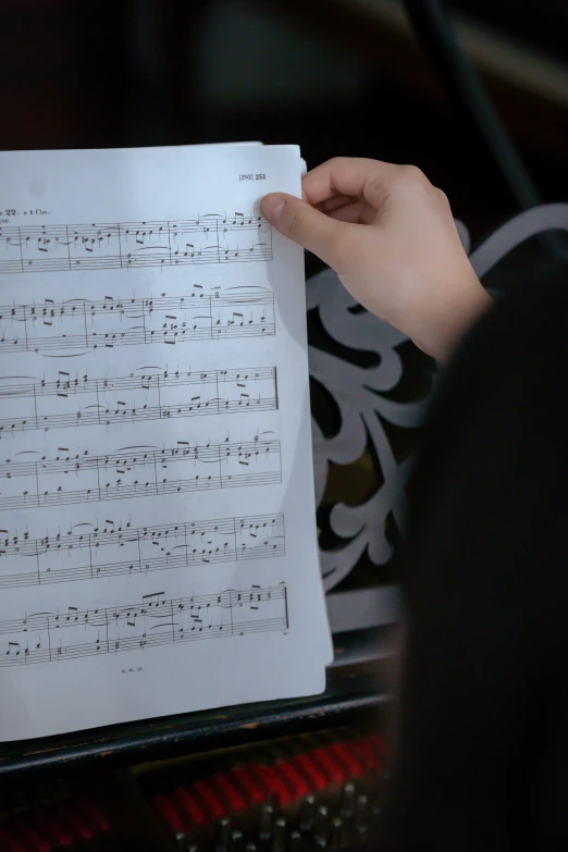 a close up of a person holding a sheet of music, thumbnail, episode, multiple stories, complex scene