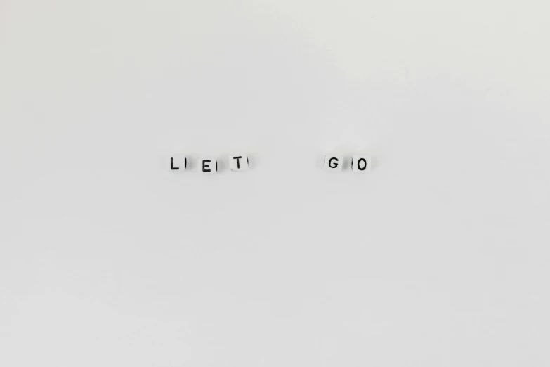 a couple of letters sitting on top of a white surface, by Cerith Wyn Evans, unsplash, of letting go, die antwoord, ghibli, let's play