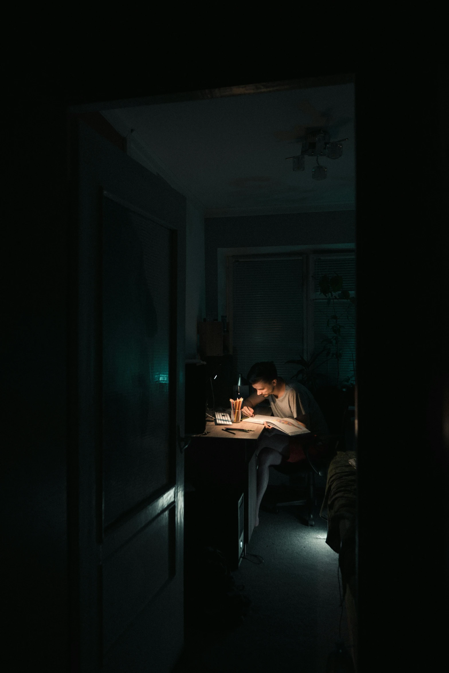 a person sitting at a desk in a dark room, by Elsa Bleda, pexels contest winner, hyperrealism, scientist, ignant, writing a letter, electricity
