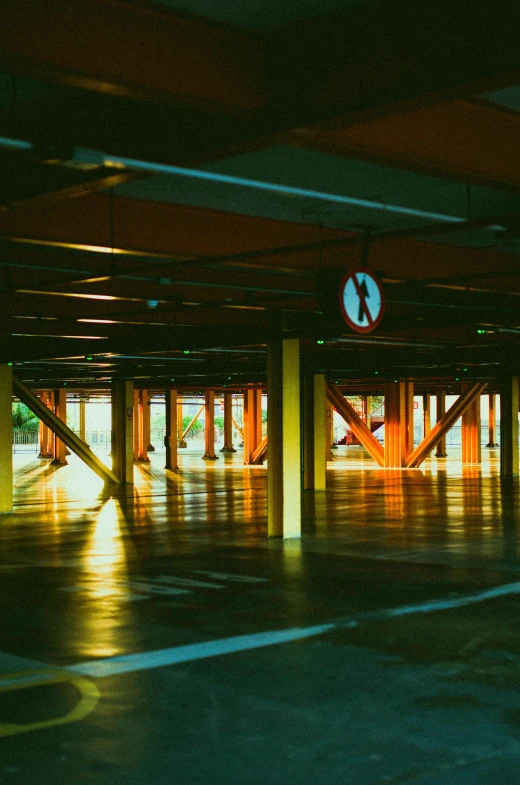 a parking garage filled with lots of parking space, an album cover, inspired by Elsa Bleda, unsplash, red and yellow light, hangar, light shadows, green floor