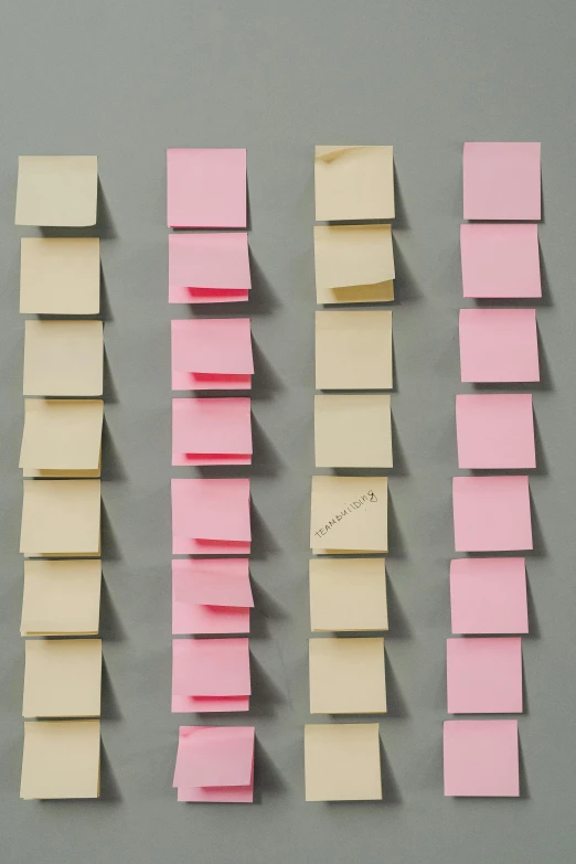 a bunch of sticky notes sitting on top of a table, adjustment of temporal matrix, pink and gold, in rows, 64x64