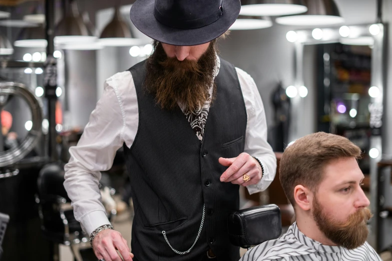 a man getting his hair cut at a barber shop, by Julia Pishtar, trending on pexels, suit vest and top hat and gloves, ned kelly, wearing a chain, wearing a fedora