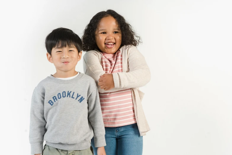 a couple of kids standing next to each other, pexels, ashcan school, half asian, product introduction photo, brooklyn, casually dressed