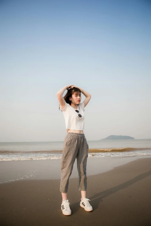 a woman standing on top of a beach next to the ocean, inspired by Kim Tschang Yeul, unsplash, wearing pants and a t-shirt, very pale skin, vietnamese woman, transparent background