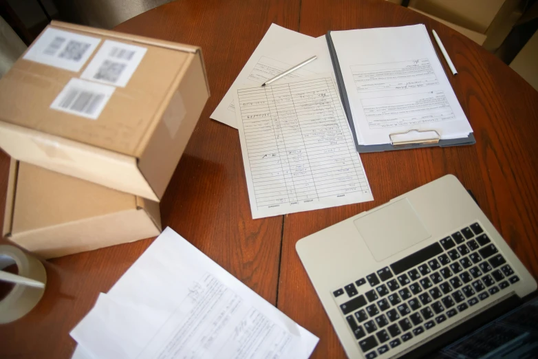 a laptop computer sitting on top of a wooden table, found papers, order, thumbnail, forms