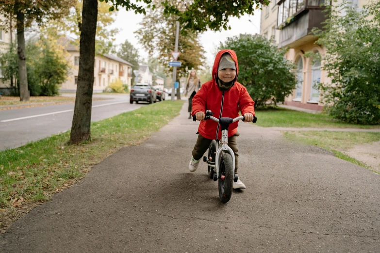 a little boy riding a bike down a sidewalk, pexels contest winner, wearing a scarlet hoodie, avatar image, havrylo pustoviyt, neighborhood