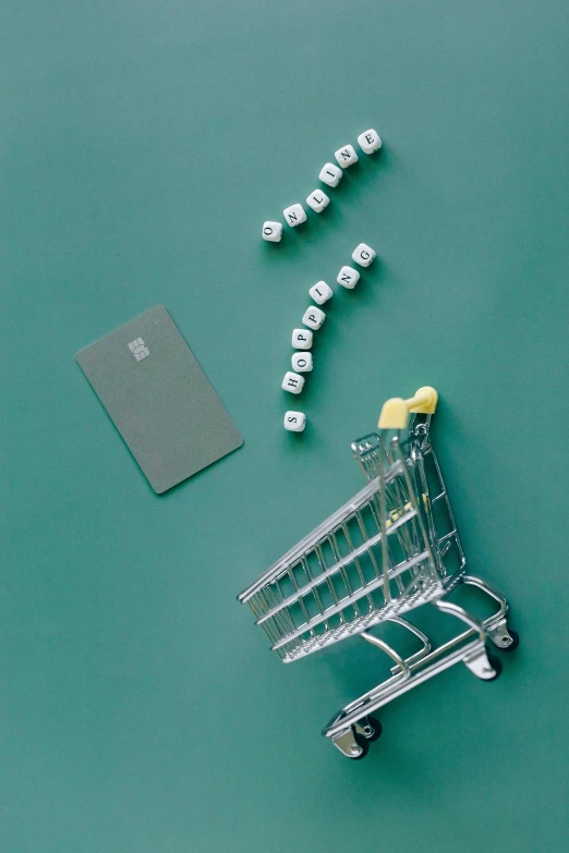 a shopping cart sitting on top of a green table, cubes on table, pair of keycards on table, 2010s, digital image