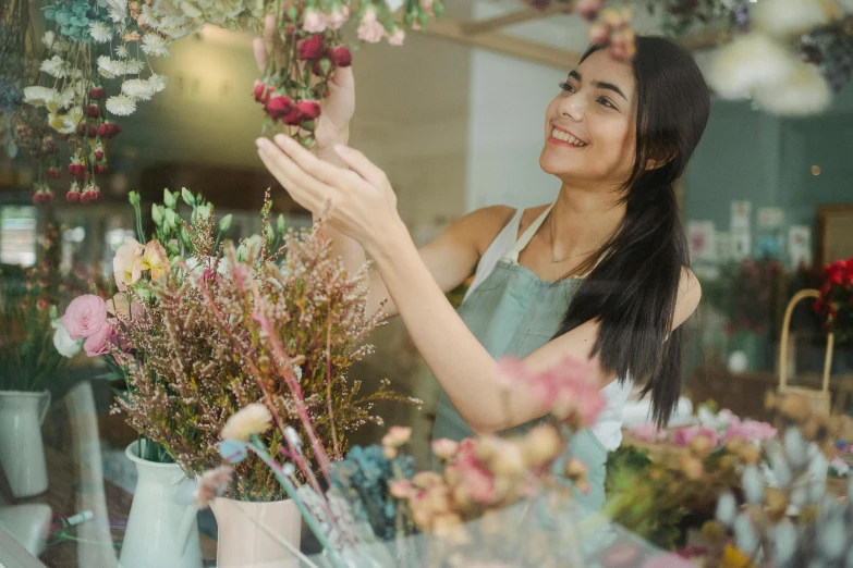 a woman looking through the window of a flower shop, pexels contest winner, smiling slightly, avatar image, pokimane, petite