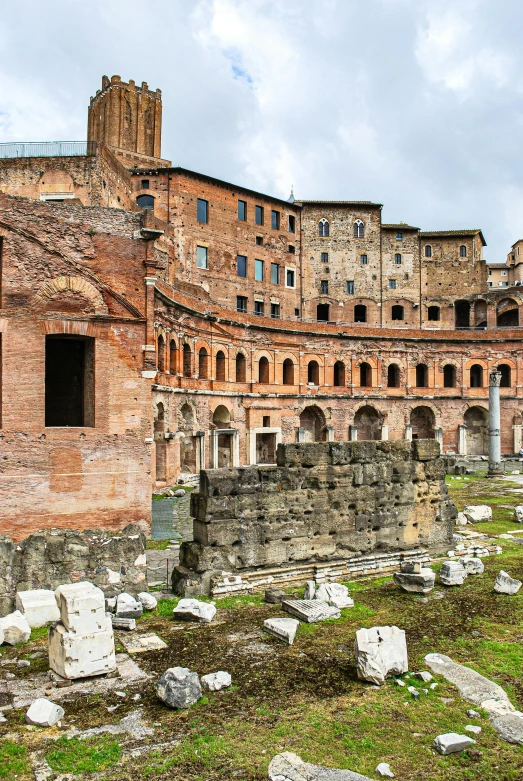 a group of buildings sitting on top of a lush green field, romanesque, julius caesar, sunken square, rusted walls, parce sepulto