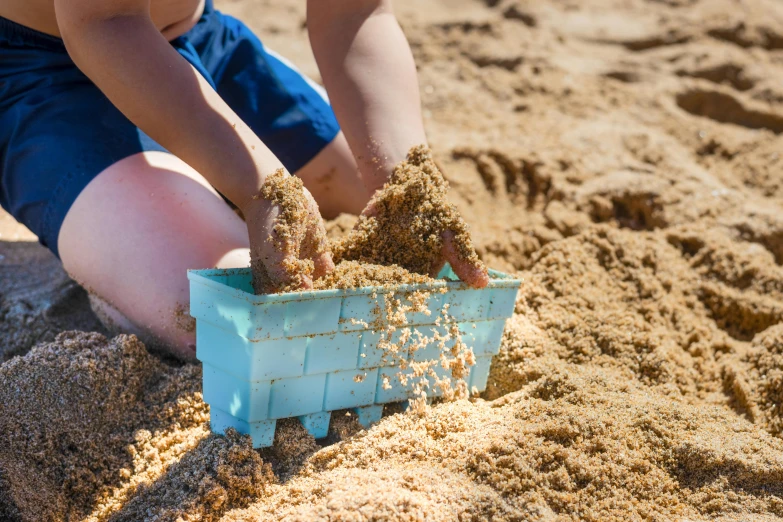 a little boy playing in the sand at the beach, by Julia Pishtar, unsplash, plasticien, looking at the treasure box, blue print, detail shot, 15081959 21121991 01012000 4k