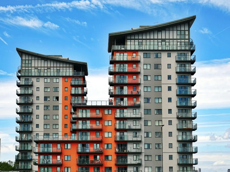 a couple of tall buildings sitting next to each other, by Carey Morris, pexels contest winner, modernism, orange grey white, ten flats, blue and red color scheme, sprawling