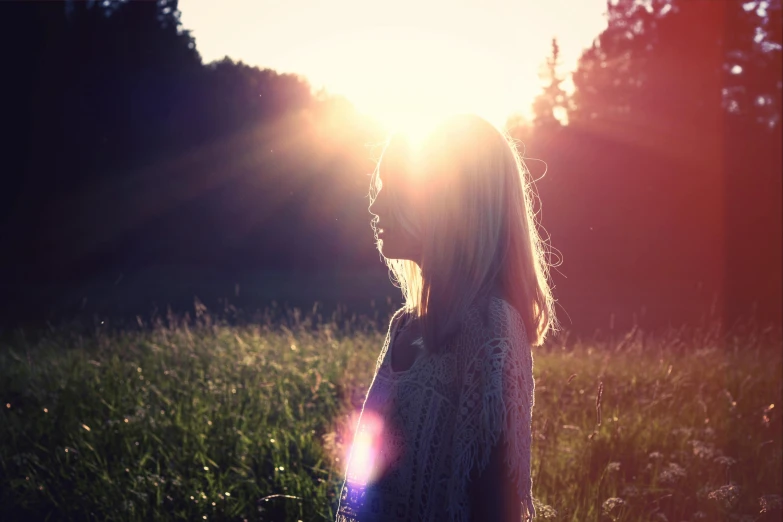 a woman standing in a field at sunset, unsplash, romanticism, sun glare, instagram post, flare, profile pic