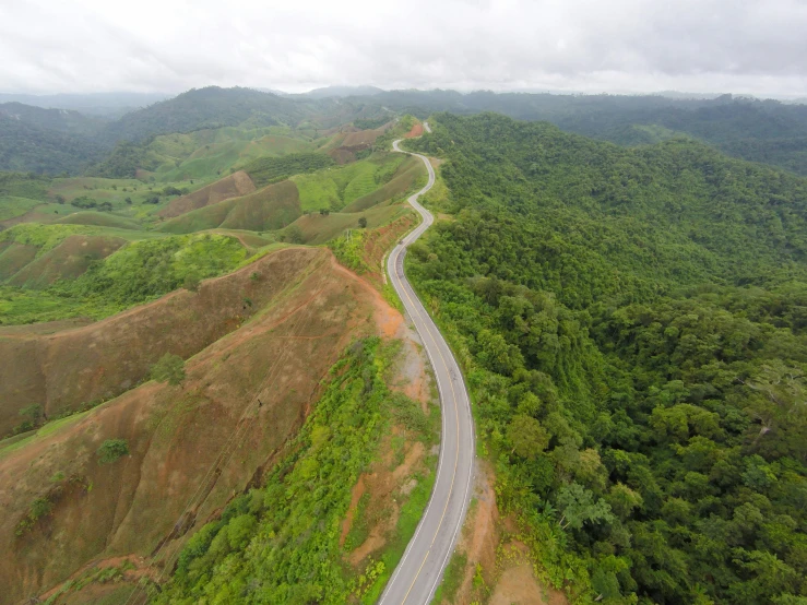 an aerial view of a winding road in the mountains, sumatraism, múseca illil, shipibo, landscape photo