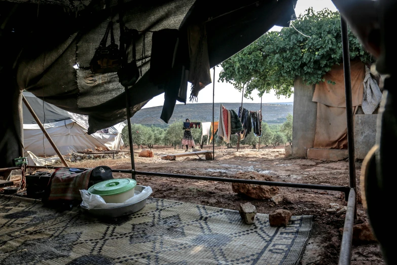 a tent in the middle of a dirt field, by Daniel Lieske, hurufiyya, inside house in village, an olive skinned, hanging, thumbnail